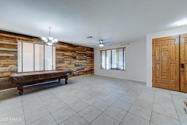 recreation room featuring ceiling fan with notable chandelier, light tile patterned flooring, pool table, and wooden walls