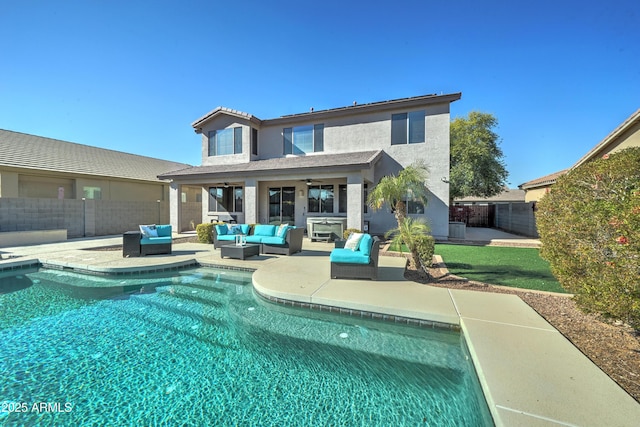 back of property with ceiling fan, a patio, outdoor lounge area, and a fenced in pool