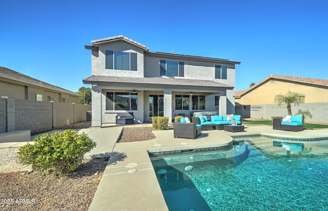 back of property with ceiling fan, a fenced in pool, an outdoor hangout area, and a patio