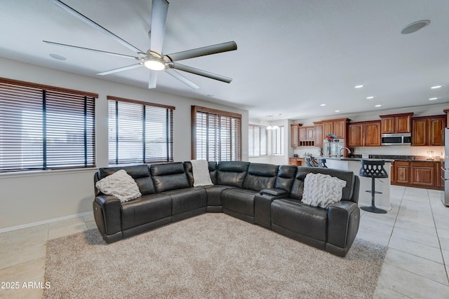 living room with ceiling fan, light tile patterned flooring, and sink