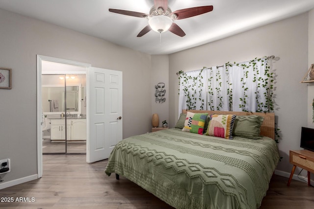 bedroom featuring a ceiling fan, ensuite bath, wood finished floors, and baseboards