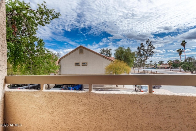 view of side of property featuring a balcony and covered parking