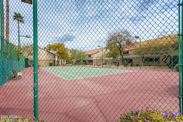 view of tennis court featuring fence