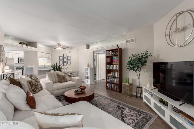 living room featuring visible vents, a ceiling fan, and wood finished floors