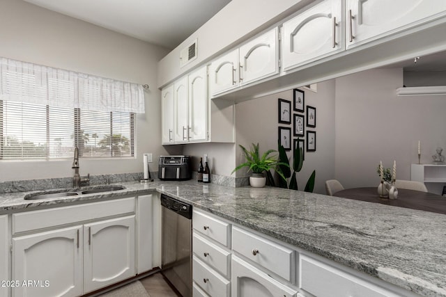 kitchen with visible vents, a sink, white cabinets, light stone countertops, and dishwasher