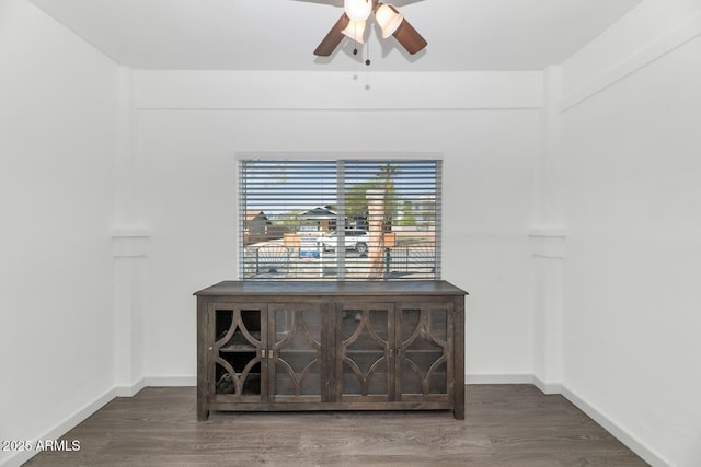 room details with a ceiling fan, baseboards, and wood finished floors