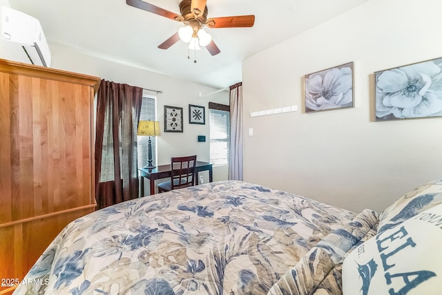 bedroom with ceiling fan and a wall unit AC