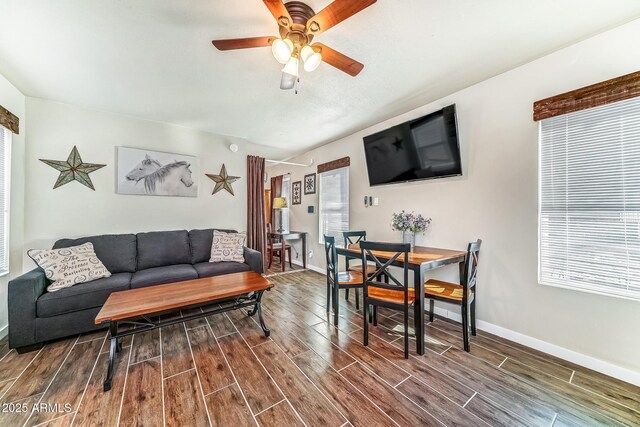 living area featuring baseboards, wood finish floors, and a ceiling fan