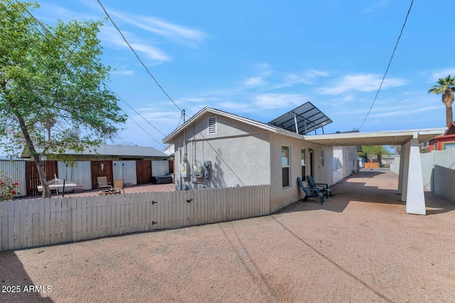 exterior space featuring stucco siding and fence