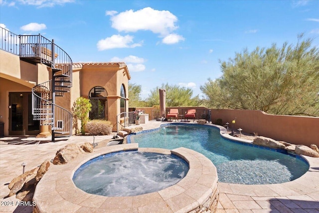 view of swimming pool with a patio and an in ground hot tub