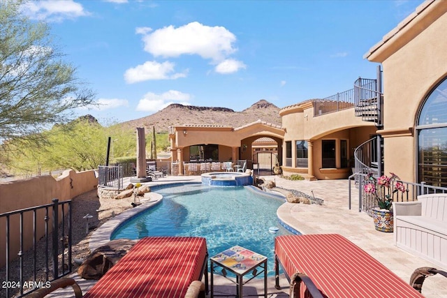 view of pool featuring an in ground hot tub, a mountain view, and a patio