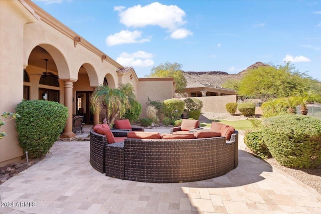 view of patio / terrace with an outdoor living space, a mountain view, and ceiling fan