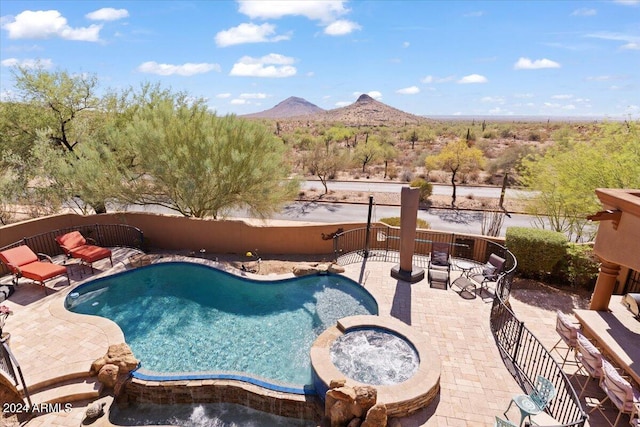 view of swimming pool featuring a patio, a mountain view, and an in ground hot tub