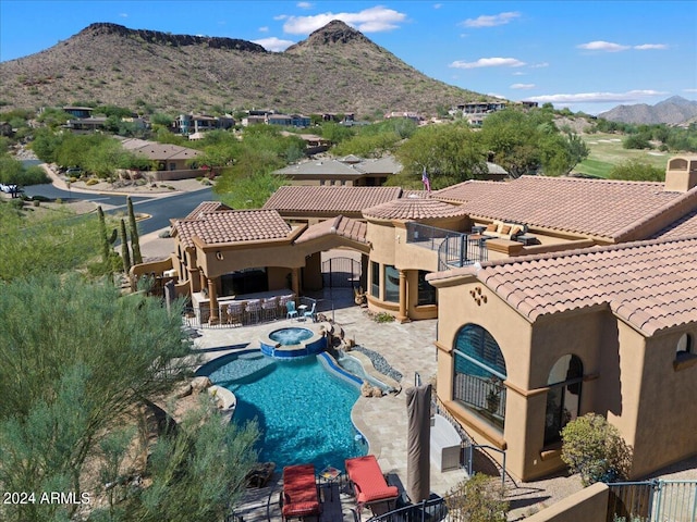 view of swimming pool featuring a patio, a mountain view, and an in ground hot tub