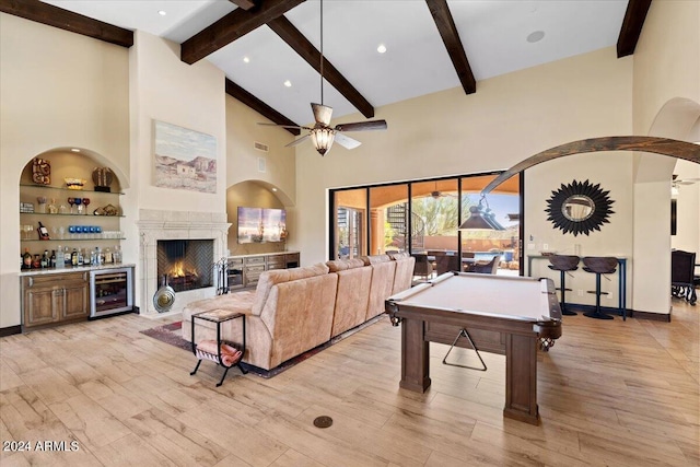 recreation room featuring light hardwood / wood-style flooring, beamed ceiling, high vaulted ceiling, and ceiling fan