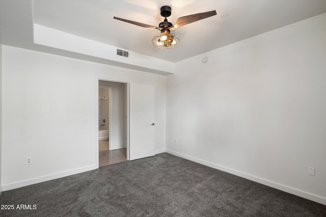 unfurnished room featuring baseboards, visible vents, dark colored carpet, and a ceiling fan