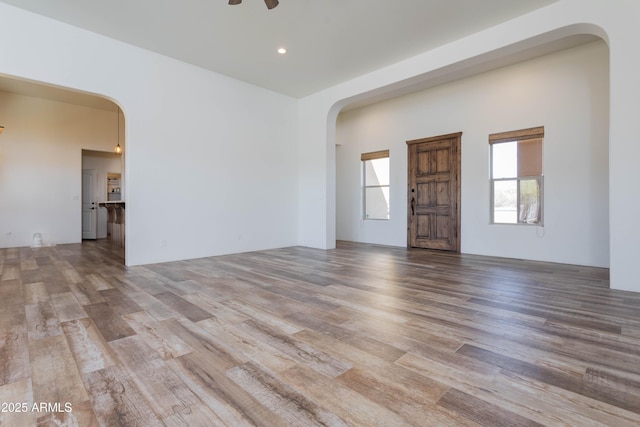 empty room with ceiling fan and light hardwood / wood-style floors