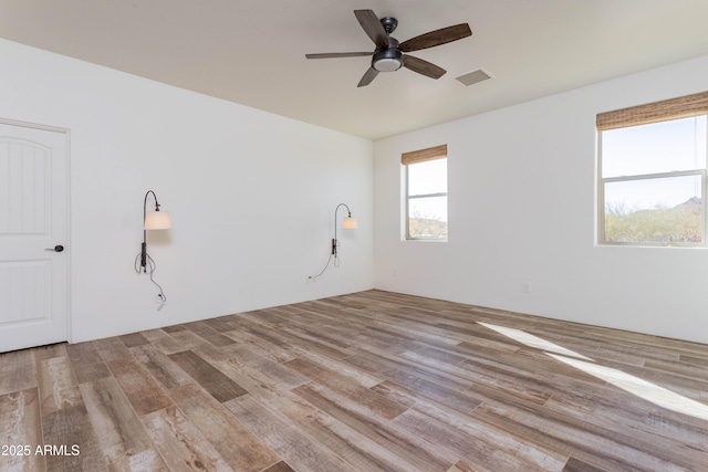 spare room with ceiling fan and light wood-type flooring