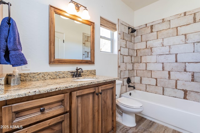 full bathroom featuring vanity, hardwood / wood-style flooring, toilet, and tiled shower / bath