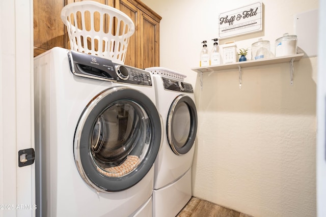 laundry area featuring cabinets, hardwood / wood-style flooring, and washer and dryer