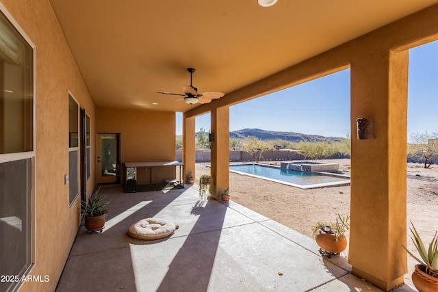 view of patio featuring ceiling fan and a mountain view