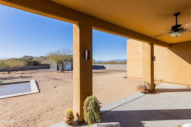 view of patio featuring ceiling fan and a storage shed