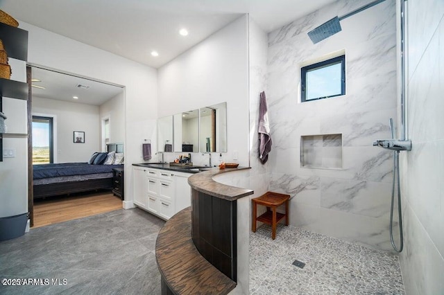 ensuite bathroom featuring recessed lighting, a marble finish shower, vanity, and ensuite bath