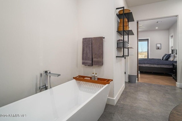 bathroom with a freestanding tub, visible vents, baseboards, and ensuite bathroom