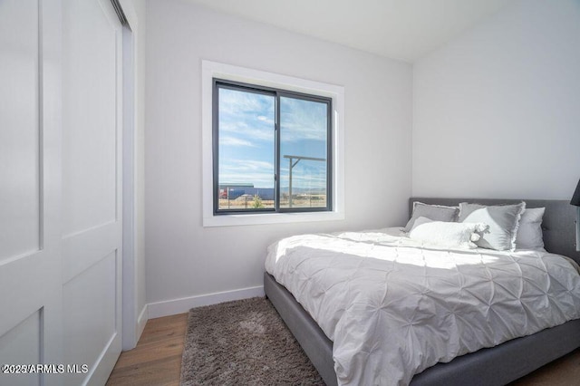 bedroom with baseboards and wood finished floors