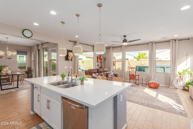 kitchen with dishwasher, white cabinets, sink, an island with sink, and decorative light fixtures