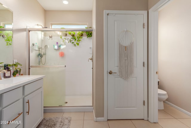 bathroom featuring toilet, vanity, tile patterned floors, and an enclosed shower