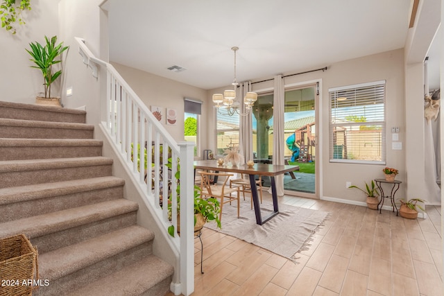 dining area featuring plenty of natural light, light hardwood / wood-style floors, and a notable chandelier