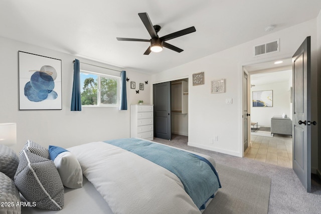 bedroom with light colored carpet, a closet, a ceiling fan, and baseboards