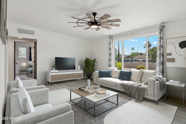 living area featuring light wood-style flooring and a ceiling fan