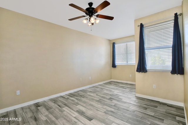 spare room featuring a ceiling fan, baseboards, and wood finished floors