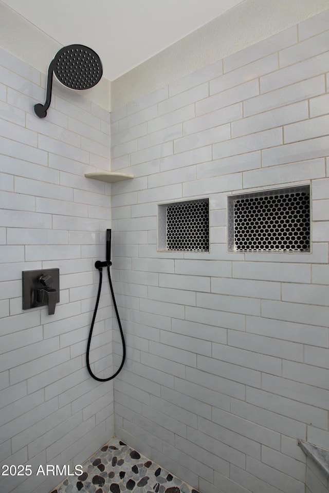 full bath with a tile shower