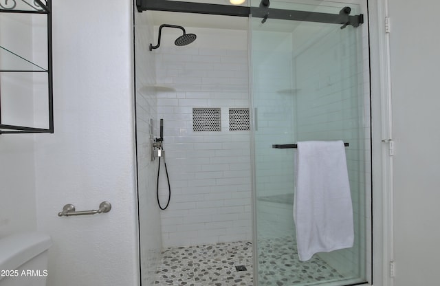 full bathroom featuring toilet and a stall shower