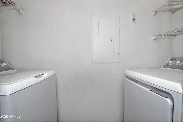 clothes washing area with laundry area, electric panel, and washer and clothes dryer