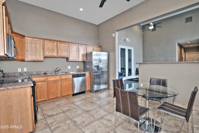 kitchen with a sink, high vaulted ceiling, stainless steel appliances, and a ceiling fan