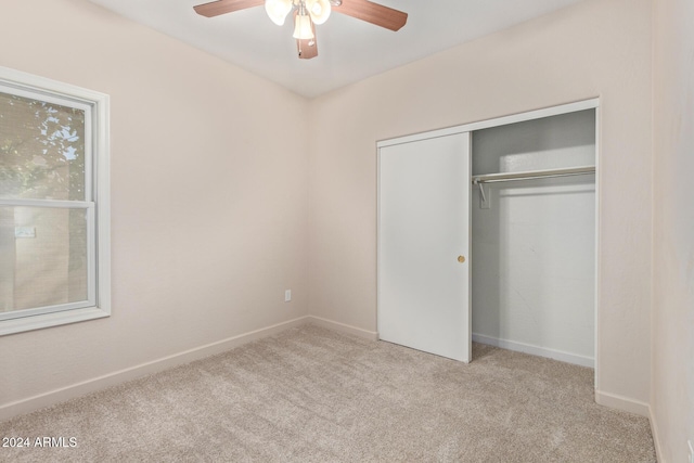 unfurnished bedroom with light carpet, a closet, and ceiling fan