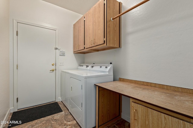 laundry room with washing machine and clothes dryer and cabinets