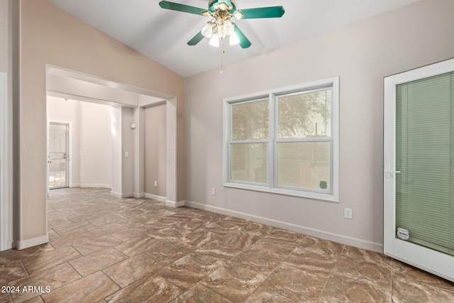 empty room with ceiling fan and lofted ceiling