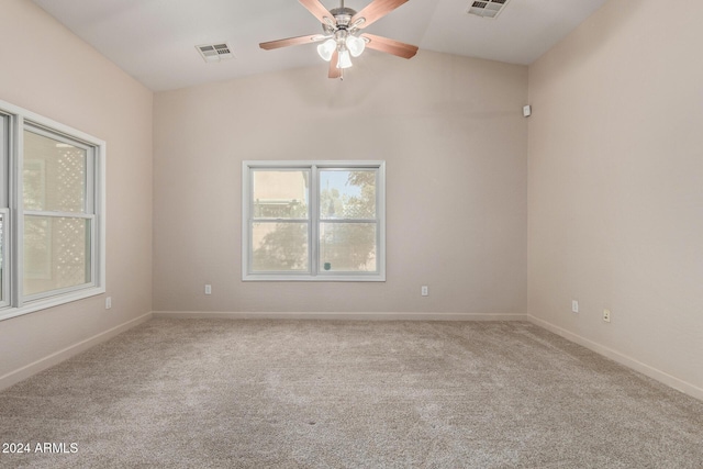 spare room with ceiling fan, light colored carpet, and vaulted ceiling