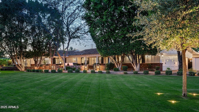 back of house featuring a lawn and board and batten siding
