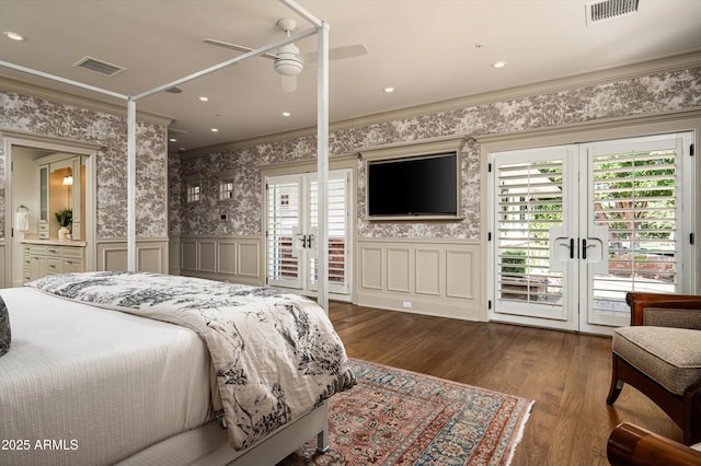 bedroom with wallpapered walls, a wainscoted wall, crown molding, and visible vents