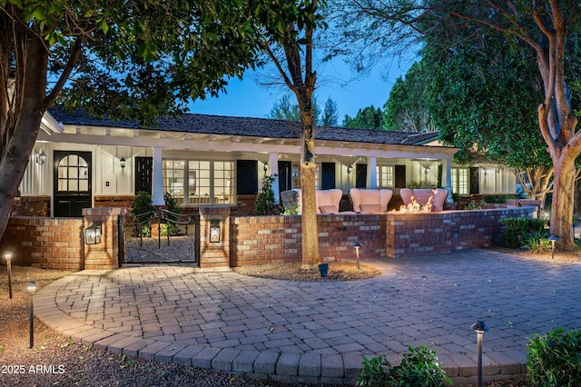 single story home featuring board and batten siding, a gate, and a fenced front yard