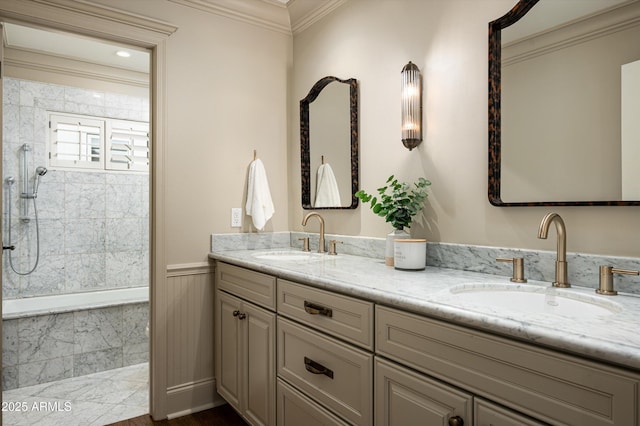 full bathroom featuring double vanity, ornamental molding, a sink, and a wainscoted wall