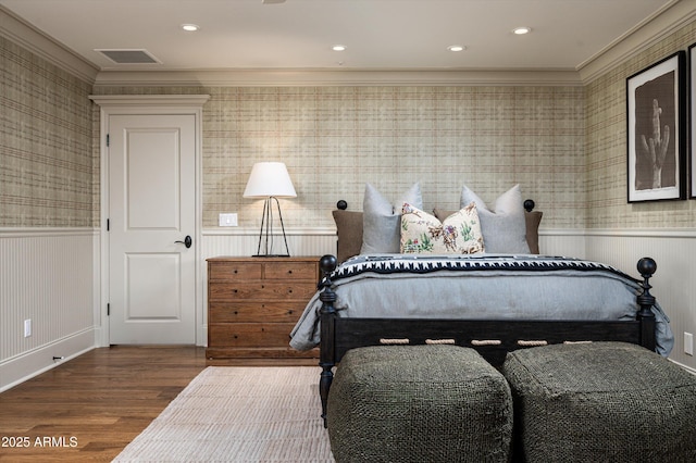 bedroom with a wainscoted wall, crown molding, wallpapered walls, wood finished floors, and recessed lighting