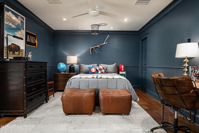 bedroom featuring a wainscoted wall, visible vents, crown molding, wood finished floors, and recessed lighting