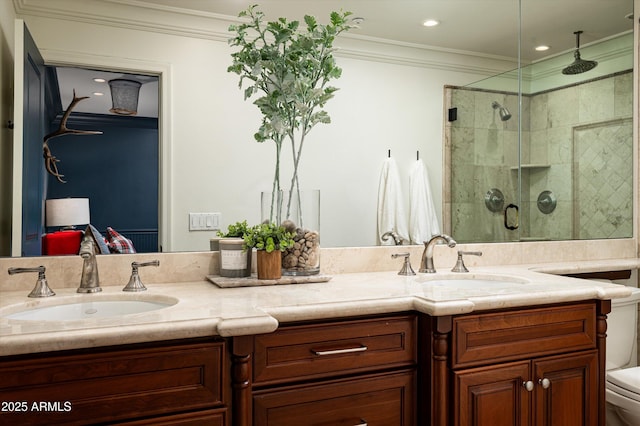 bathroom with toilet, a sink, a stall shower, and crown molding
